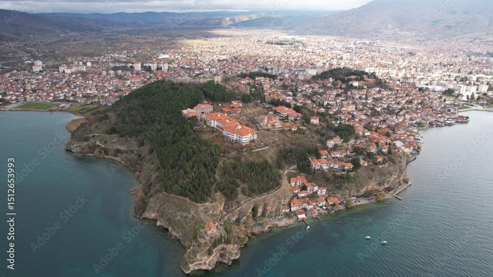 Fototapeta premium Historic Samuel's fortress overlooks serene coastal town with modern architecture under cloudy sky, Ohrid 