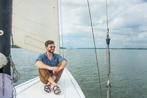 Papier peint Young man sitting on yacht in sea, copy space.
