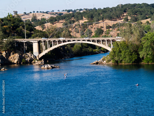 Bridge Over River With Hills And Kayaks