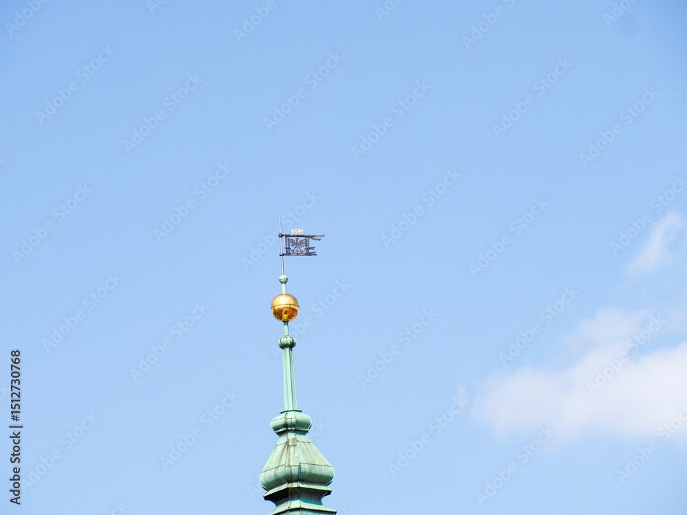 Historic baroque church tower with golden cross against blue sky on Constitution Day in Warsaw Historic baroque church tower with golden cross against blue sky on Constitution Day in Warsaw