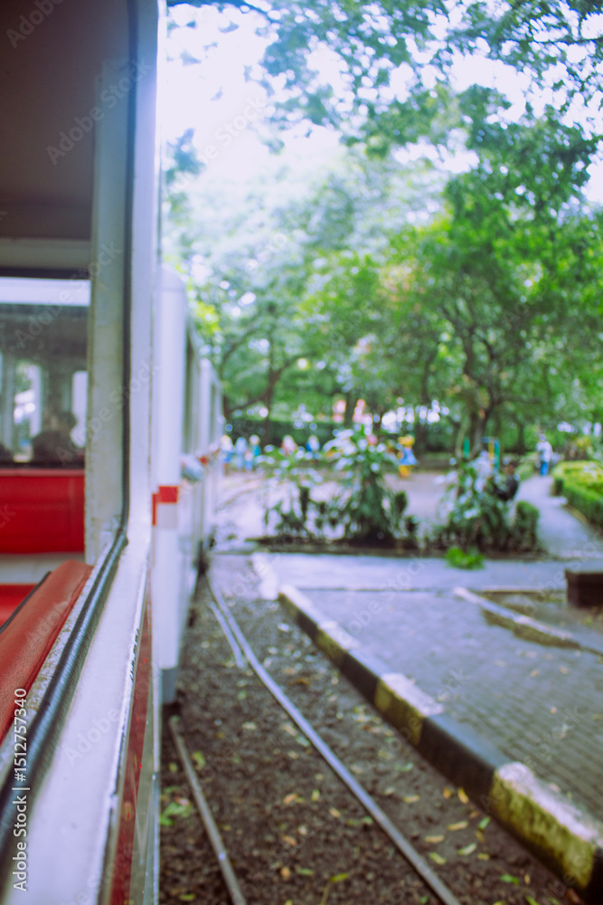 Obraz premium Scenic View of City Park from Open-Air Train Window