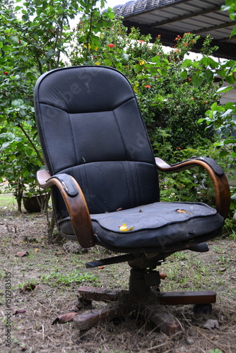Foto Weathered office chair amidst lush greenery