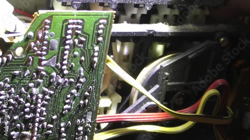 A man repairs an old tape recorder. Hands collect the hardware board.