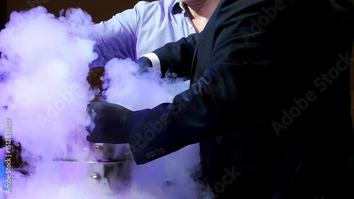 Making a smoky cocktail from dry ice at a party. The bartender makes a show dish of dry ice with smoke.