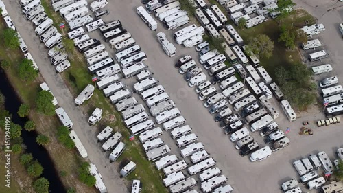 Dealers outdoor parking lot with many brand new travel trailers and campervans in stock for sale. Concept of development of American RV automotive industry.