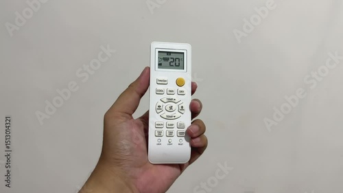 Hand Holding Remote Displaying 20 celcius
Description: Close-up of a hand holding a remote control showing 20 celcius on the display; appliance control and user interaction concept.