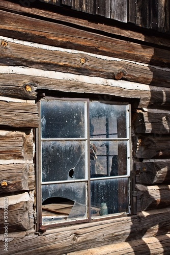 Broken window in an old log cabin. Jerome, Arizona.