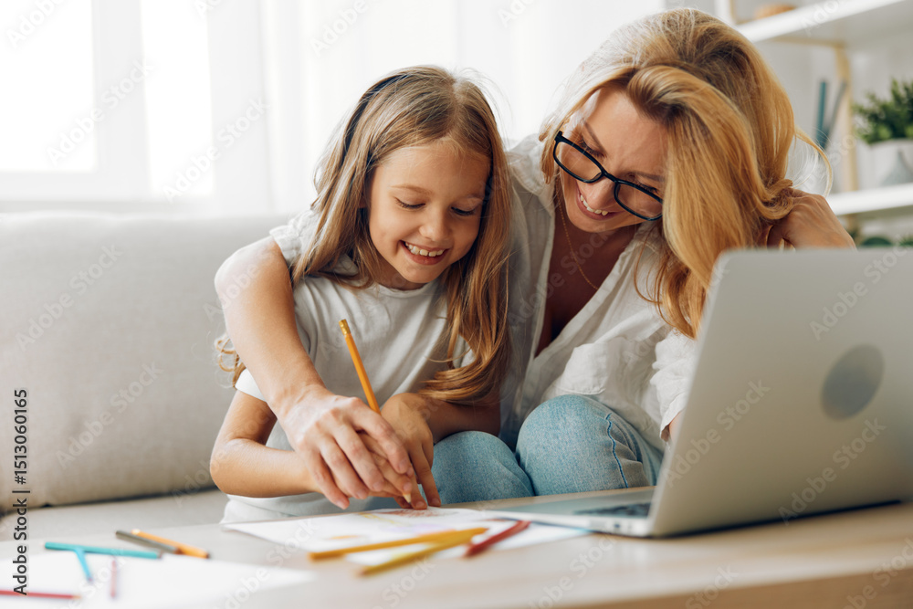 Mother and daughter bonding on the couch, working on a creative project with a laptop and colored pencils Mother and daughter bonding on the couch, working on a creative project with a laptop and colored pencils