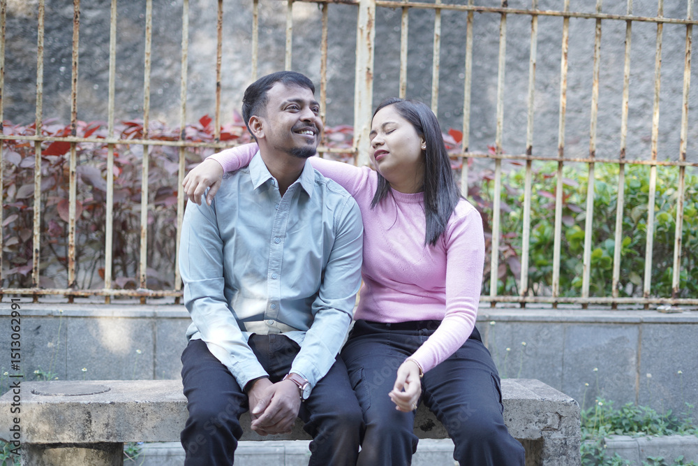 Fototapeta premium A joyful young couple sharing a loving moment on a peaceful street surrounded by greenery