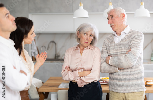 Young woman introducing her future wife to her mom and dad demonstrating disagreeable attitude towards him at home