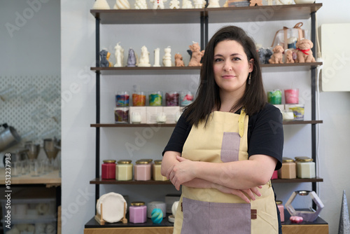 Confident artisan posing in her candle workshop