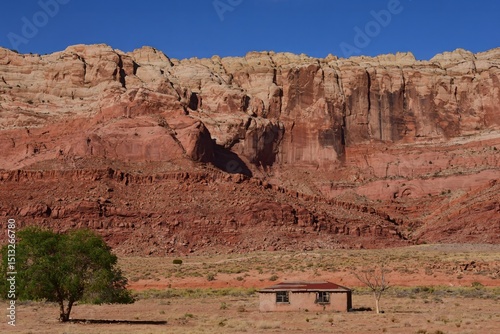 spectacular cliffs and an abandoned farmhouse on a sunny summer day   along us highway 89 on the way to lake powell, south of  page,  northern arizona