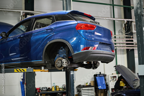 Car repair service. The auto is on a lift.