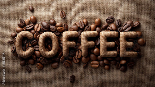 Creative coffee typography made with beans and burlap on natural fabric background, flat lay food art