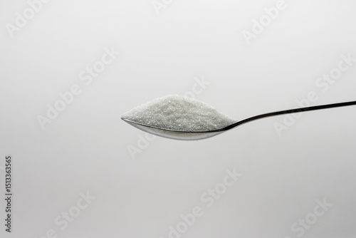 Tableau sur toile Close-up of a Spoonful of Granulated Sugar A Detailed Look at Sweetness and Text
