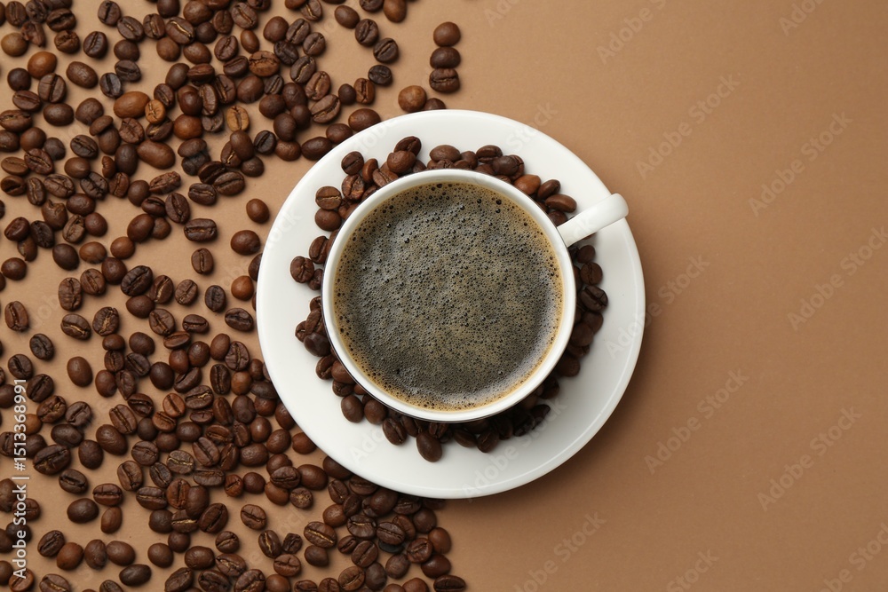Fototapeta premium Aromatic coffee in cup and beans on beige background, flat lay