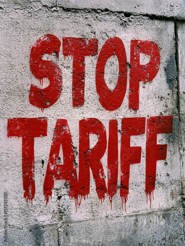 Urban street graffiti message STOP TARIFF painted in red on textured concrete wall symbolizing defiance and political protest photo