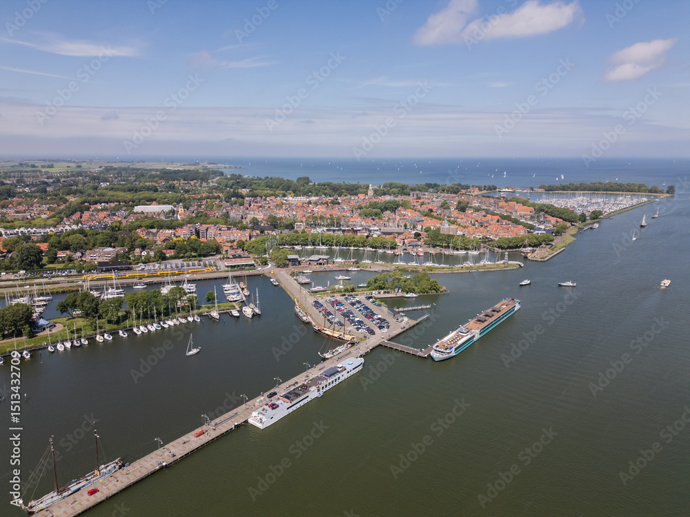 Naklejka premium Aerial drone footage of historic picturesque Dutch city Enkhuizen with boats and yachts Netherlands harbor port water Ijsselmeer on sunny summer day