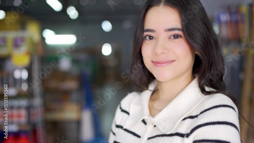 Young latin american saleswoman smiling and posing in a hardware store