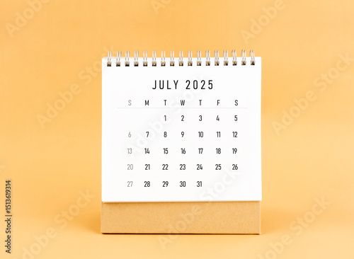 July 2025 desk calendar on yellow background, Front view.