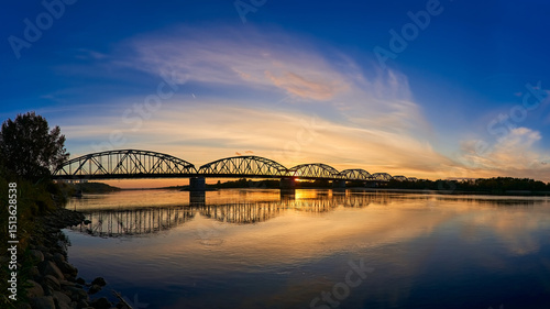A large panoramic shot of the bridge over the river against the sunset background. An epic photo of the bridge