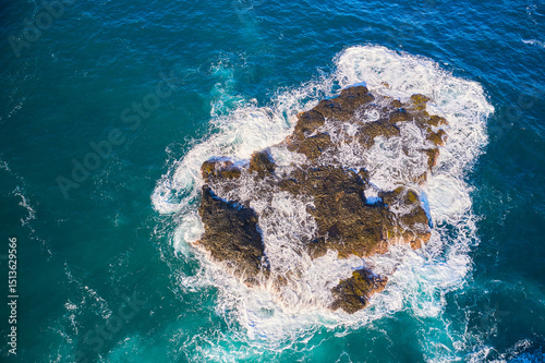 Powerful surf breaks on beautiful rocks on a small island