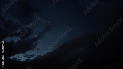 Strange and beautiful black clouds moving in a dark blue sky