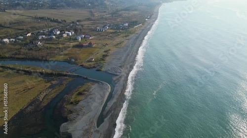 Discover an enchanting landscape along the Adjara coastline in Georgia, where the vibrant river flows into the vast Black Sea, intricately shaping the shoreline.
