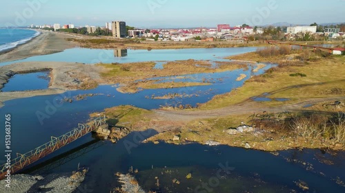 Explore the stunning landscape of Adjara, Georgia. This captivating aerial view reveals winding rivers, lush fields, and vibrant neighborhoods. Experience the natural beauty and tranquil environment.