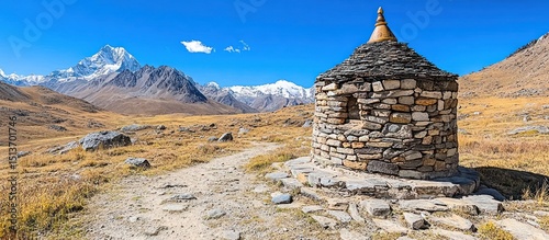 Ancient stone shrine in a mountainous landscape under clear blue sky