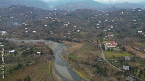 Explore the stunning landscape of Adjara, Georgia. This captivating aerial view reveals winding rivers, lush fields, and vibrant neighborhoods. Experience the natural beauty and tranquil environment.