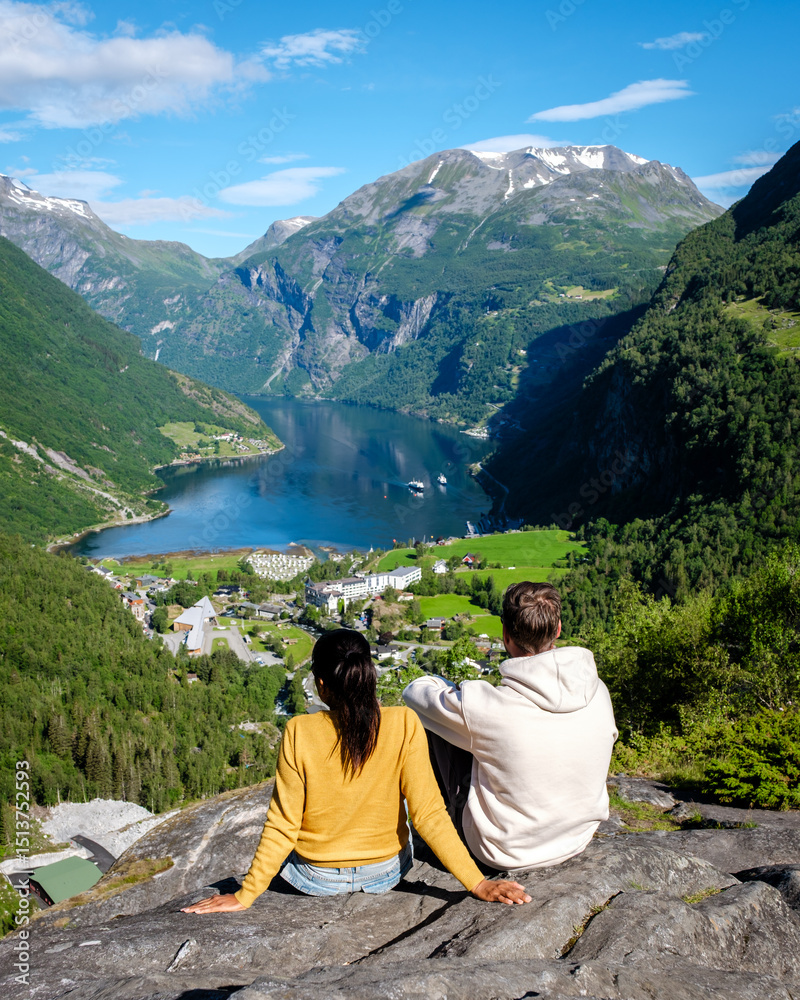 Fototapeta premium Scenic view of a couple enjoying nature in Geirangerfjord, Norway under a bright blue sky