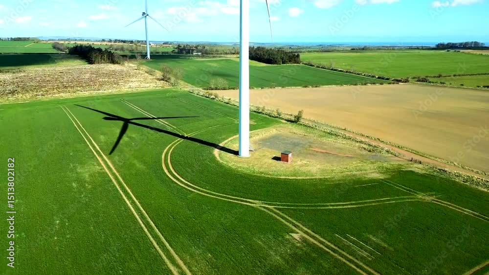 Drone shot of turbines spin gracefully, generating clean energy across vast green countryside