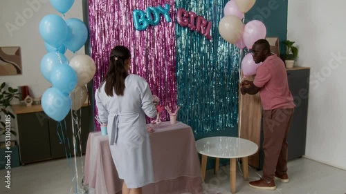 Wallpaper Mural Full zoom-in shot of multiethnic young couple preparing for gender reveal party at home. African American husband decorating living room with balloons, pregnant Hispanic wife bringing desserts Torontodigital.ca
