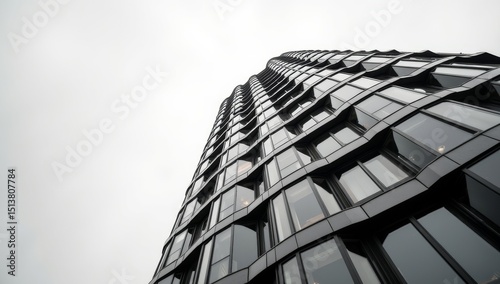 Perspective of high rise building and dark steel window system with clouds reflected on the glass. Business concept of future architecture, lookup to the angle of the building corner.