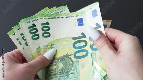 Women's hands counting money. 100 and 50 euro notes