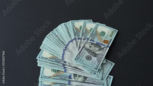 A fan of money falls on the table. Dollars
