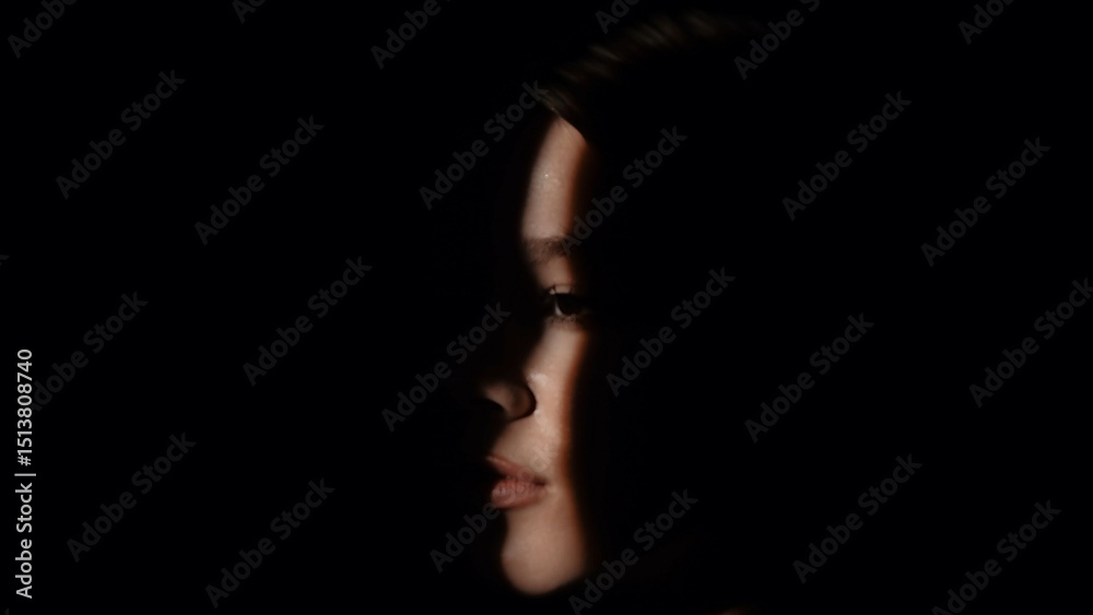 Obraz premium Captivating Portrait with Dramatic Shadow Play and Light Beam