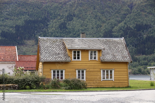 Nordfjordeid, Norway. 31-05-2025. A yellow old wooden house. With roof slates.
