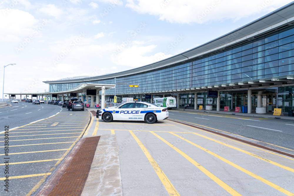 Naklejka premium Mississauga, Ontario, Canada - May 7, 2025: Police cars parked at the passenger drop-off area in Pearson International Airport in Mississauga, Ontario, Canada.