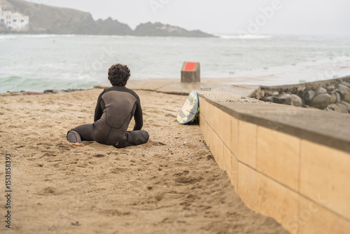 Surfer stretching on the beach before entering the sea