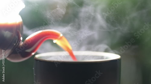 Steaming mug of americano coffee poured from a pot dark green background beverage concept cozy environment close-up view.