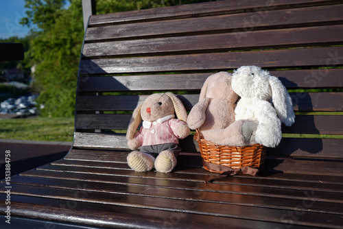 A lot of plush hares on a bench in a basket