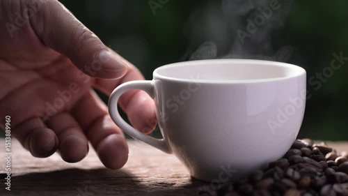 Hand holding a Steaming recycled paper coffee cup with americano coffee green environment close-up viewpoint