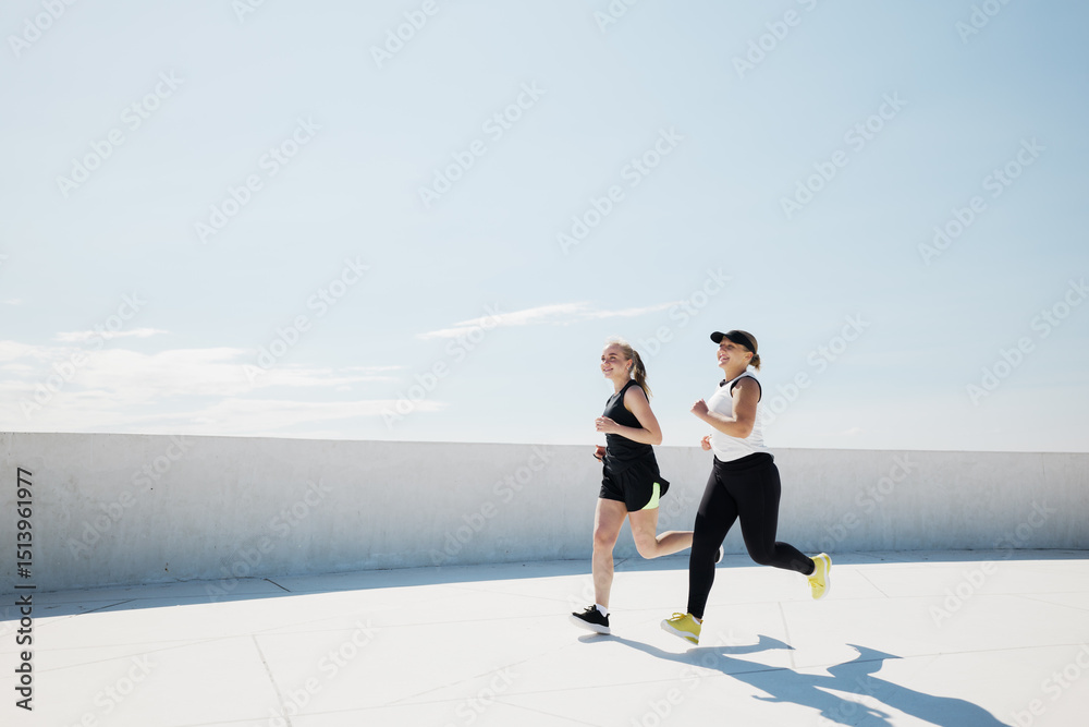 Obraz premium Dynamic duo enjoying a vibrant run under the bright sky on a warm afternoon providing a refreshing experience