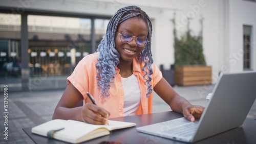 Quadro su tela Camera moving closer to cute African American girl with glasses sitting at table outside