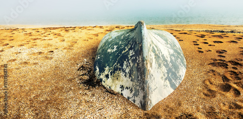 The inverted boat was washed away by sand on the sea beach after a big storm, the winter storm was felt severely