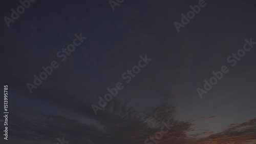 Timelapse of clear sky at sunrise with scattered clouds and chemtrails