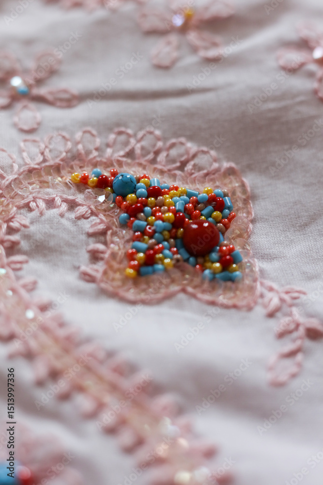 Obraz premium Beautiful embroidery on a pink fabric. Close-up.