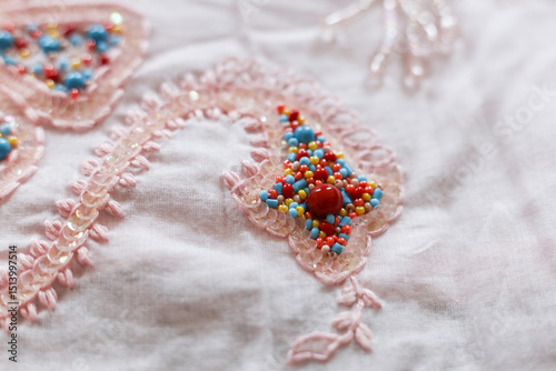 Beautiful embroidery on a pink fabric. Close-up.